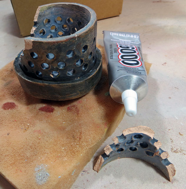 Broken ceramic pieces with glue tube