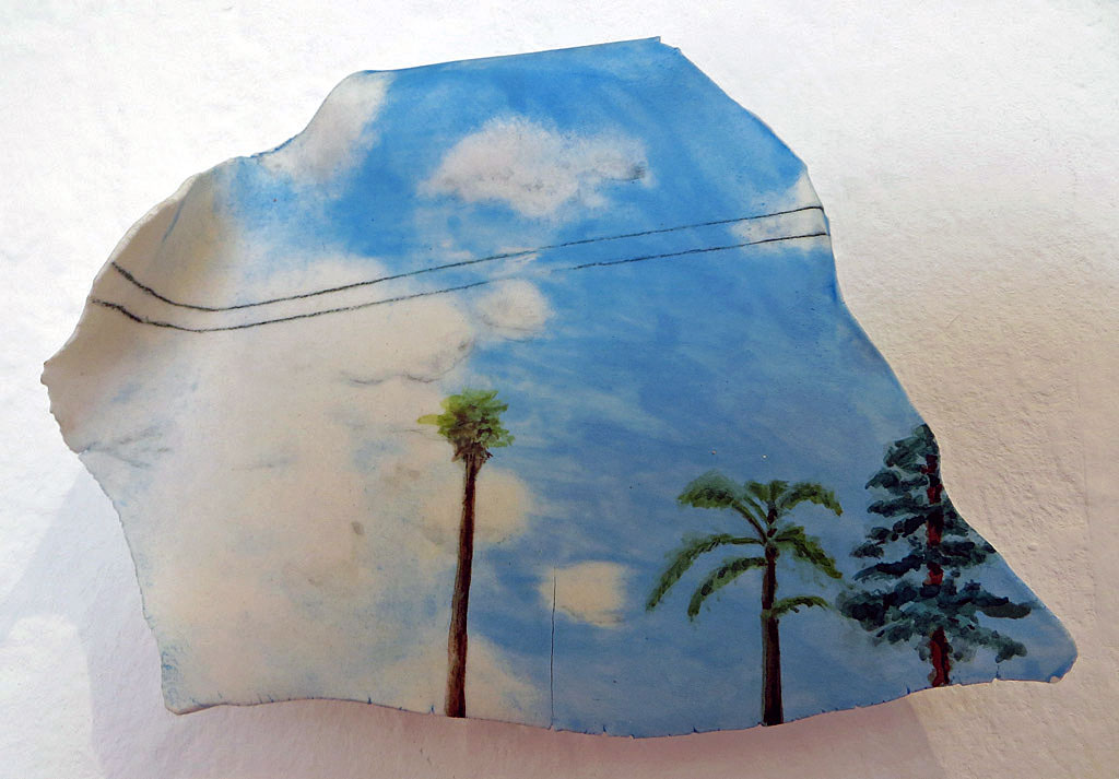 Small ceramic tile of sky, clouds, palm and pine trees